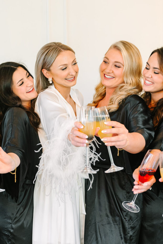 Bride and bridesmaids toasting mimosas