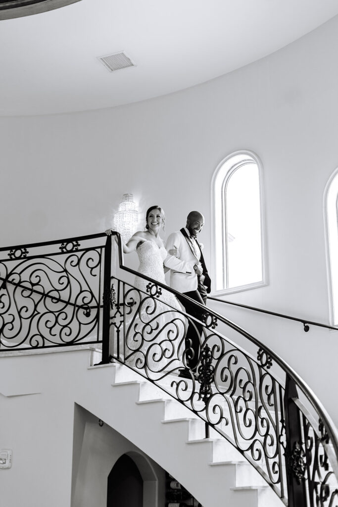 Bride and groom walking down staircase 