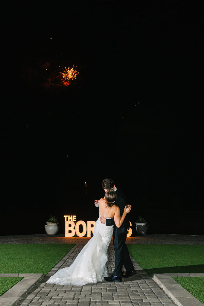 Bride and groom watching fireworks at wedding reception