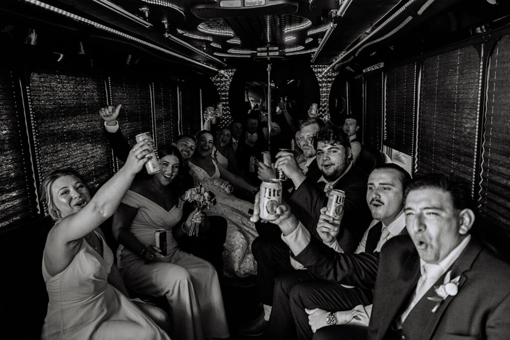 Bride and groom with wedding party on party bus