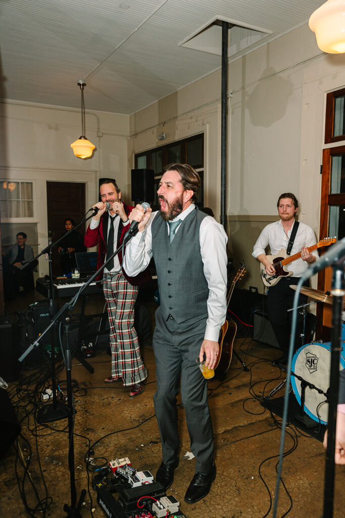 Groom singing with his band during wedding reception