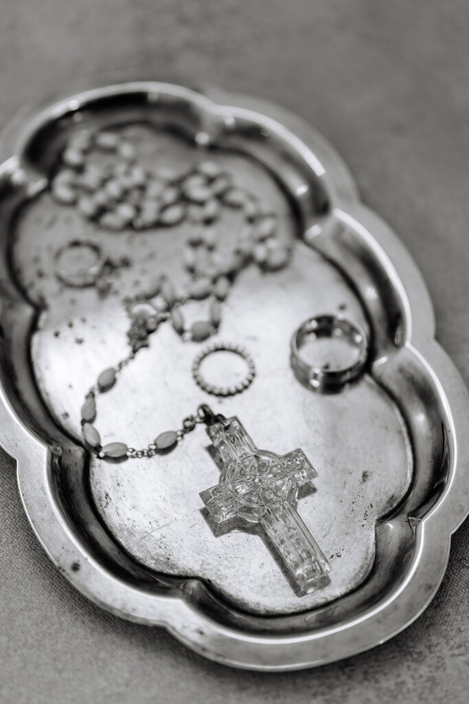 A cross and wedding rings in a dish