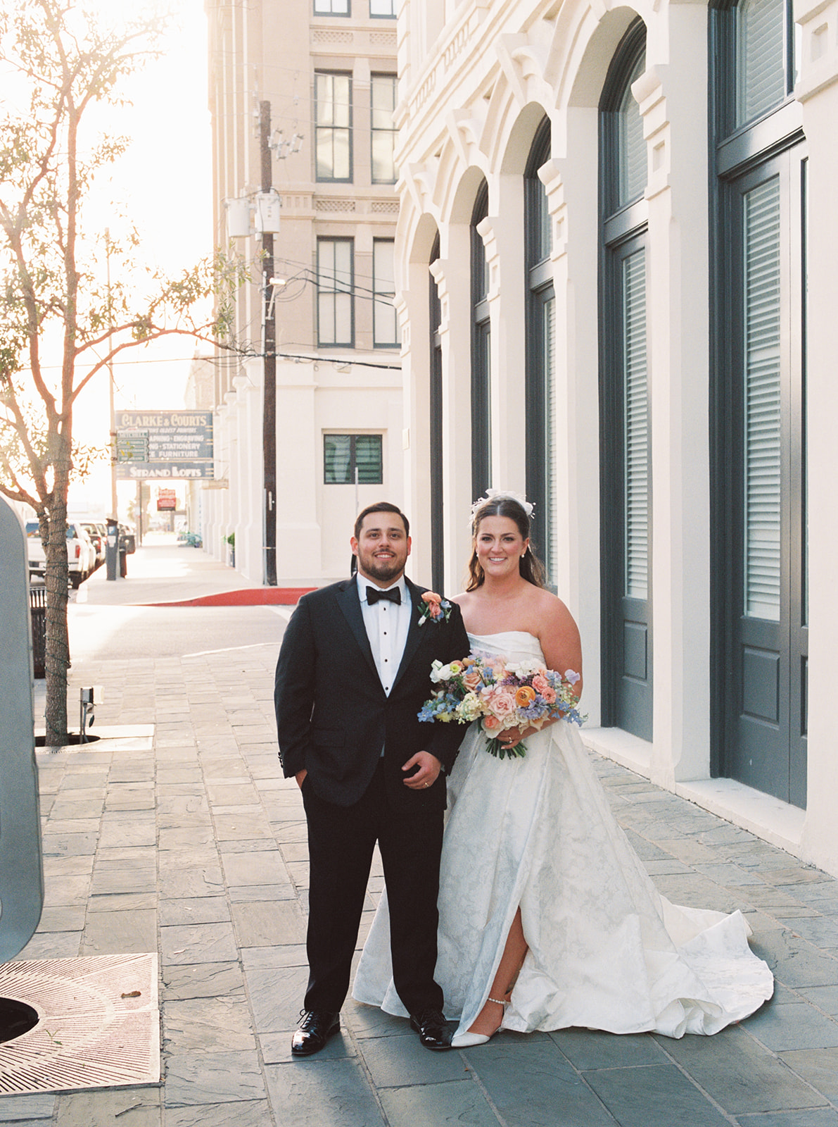 bride and groom take romantic wedding portraits outside of the tremont house in galveston