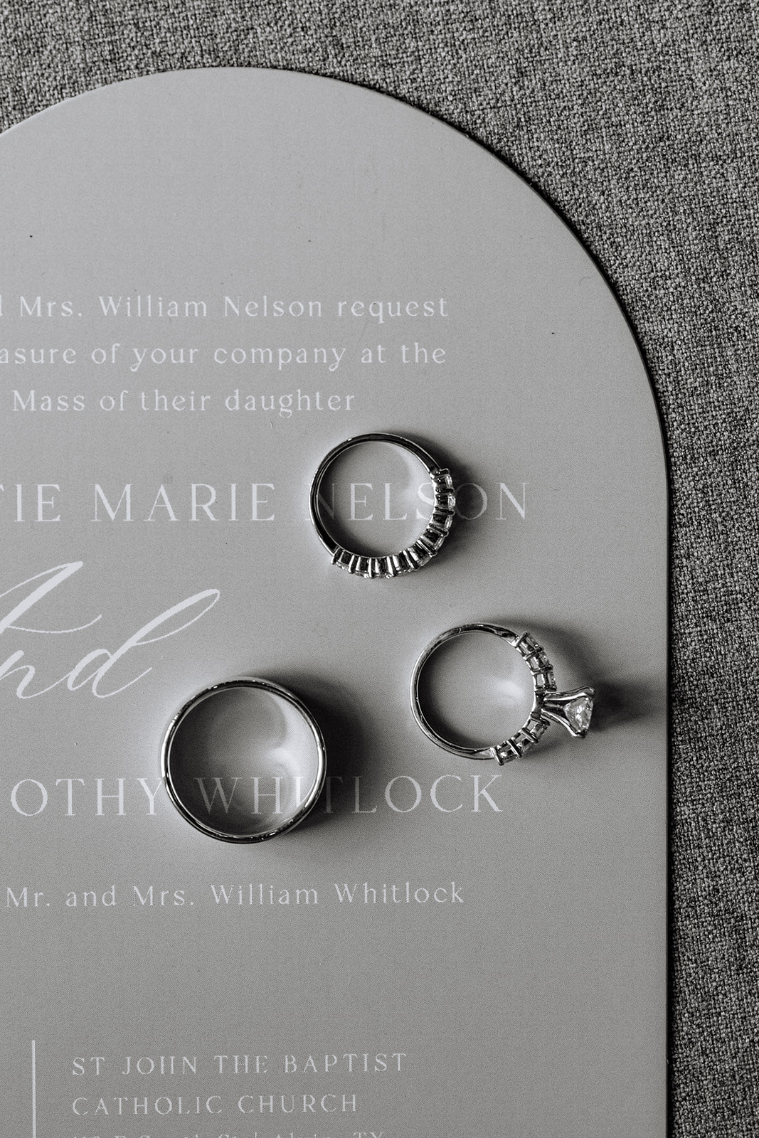 Three pink and white wedding invitations with gold wax seals and assorted flowers arranged around them on a beige surface for a pink summer wedding 