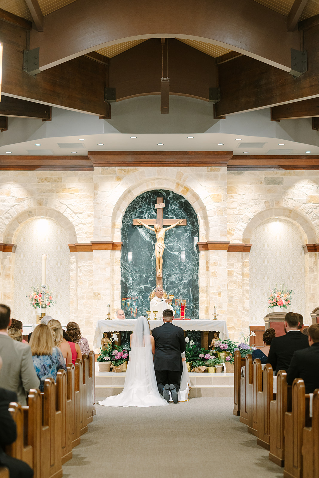 a pink summer wedding ceremony at a catholic church while a bride walks down the aisle