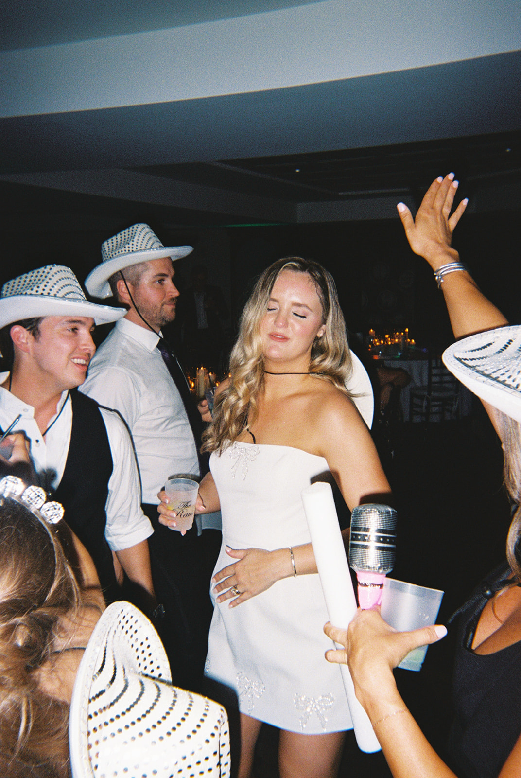 A group pf people dance on the dance floor for a wedding 