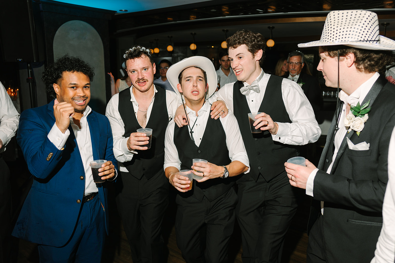 A group pf people dance on the dance floor for a wedding at Magnolia Hotel in Houston