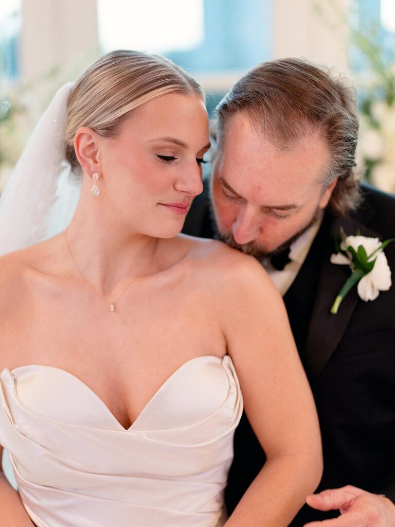 groom kissing the bride on the shoulder