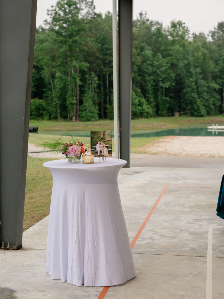 Cocktail table with florals overlooking the lake at the family camp rehearsal dinner