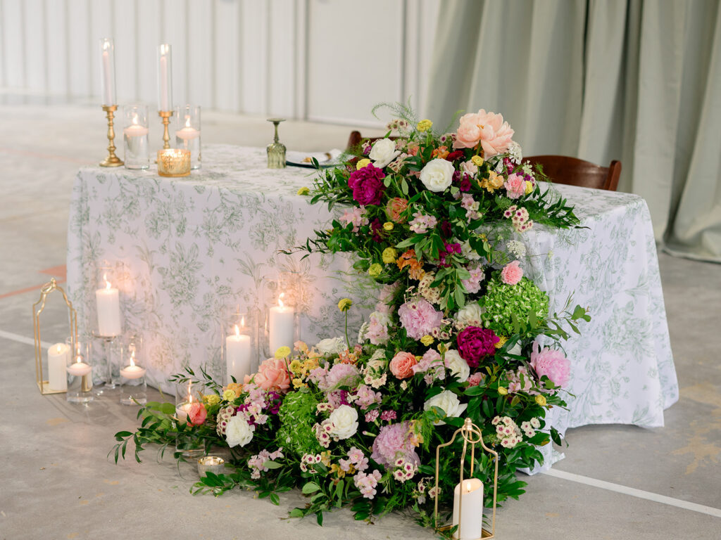 Sweetheart table with garden florals and candlelight at the rehearsal dinner