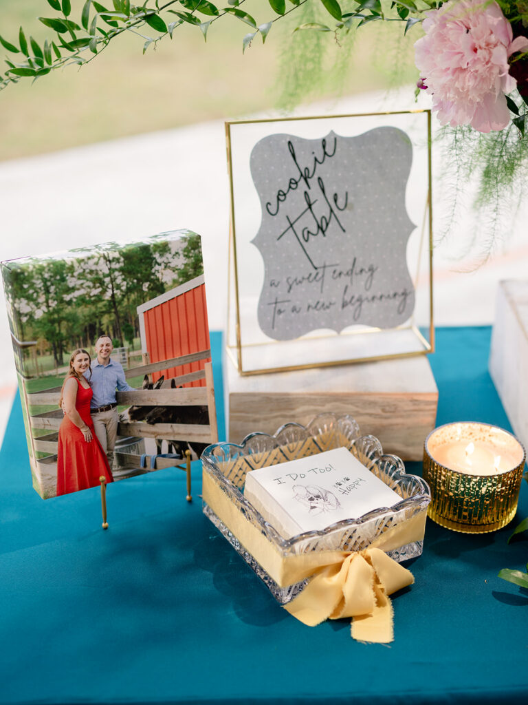 Cookie table sign reading a sweet ending to a new beginning at the rehearsal dinner