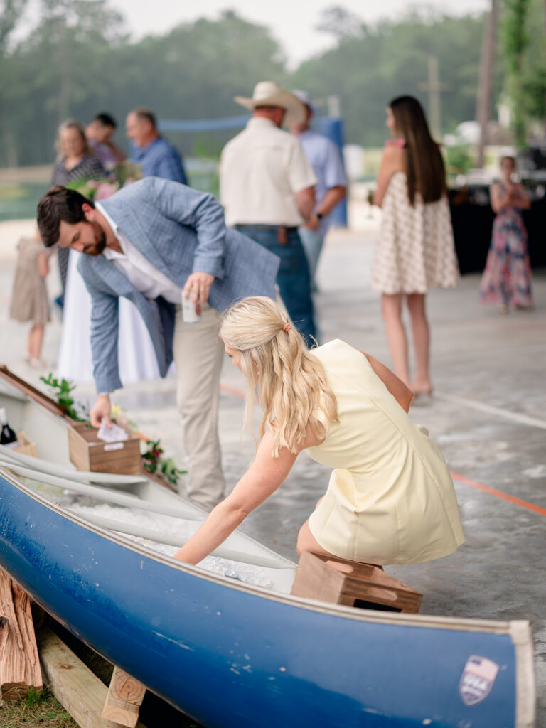 Guests grabbing drinks from the canoe cooler at the rehearsal dinner