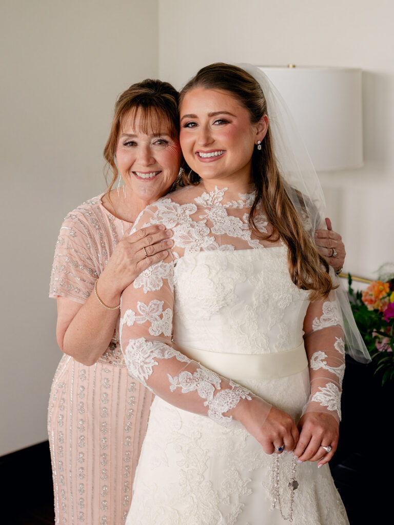 Bride and her mother cheek to cheek in the getting ready suite
