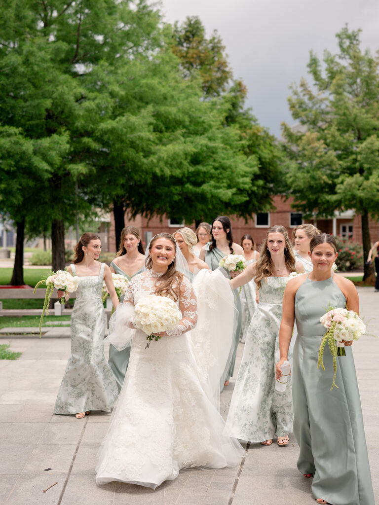 Bride walking with bridesmaids in sage and green toile gowns