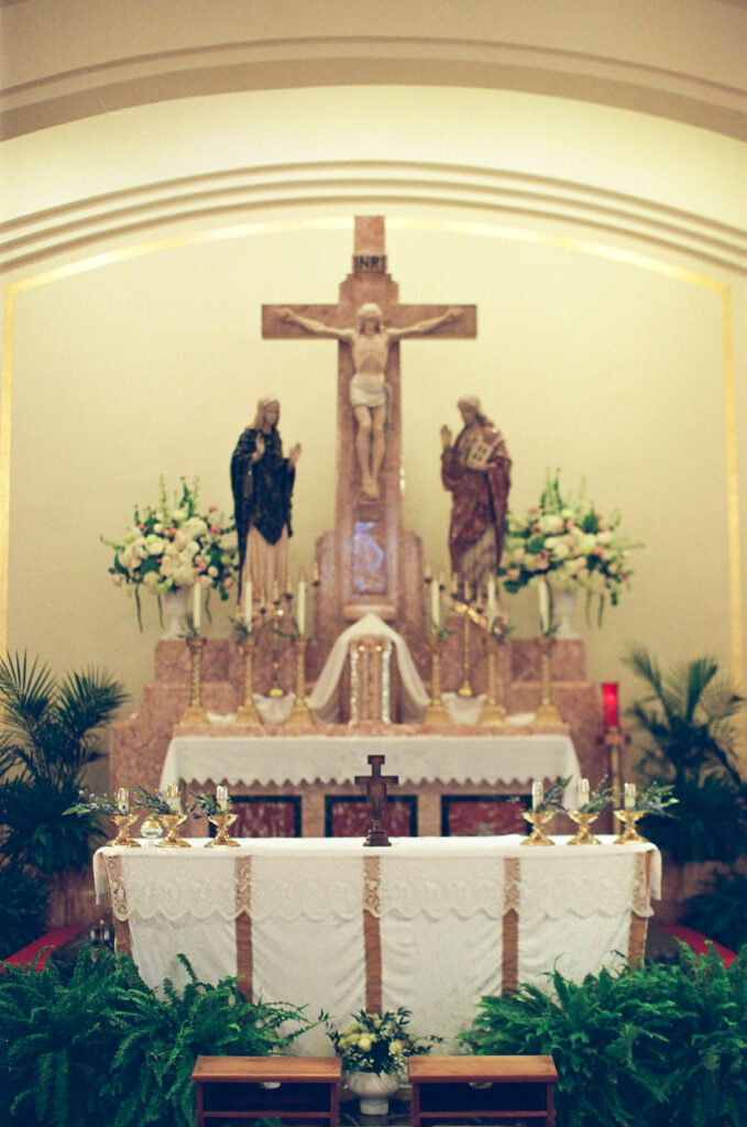 Catholic church altar with white florals, photographed on film