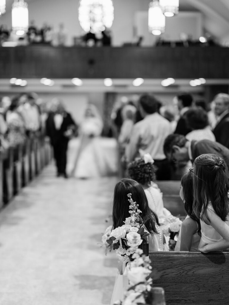 Black and white photo of the bride's entrance through the guests