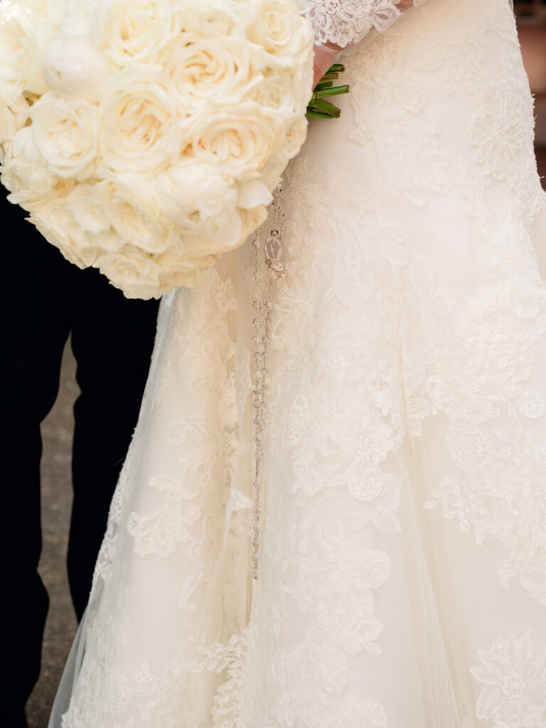 Ivory rose bouquet against the bride's lace gown
