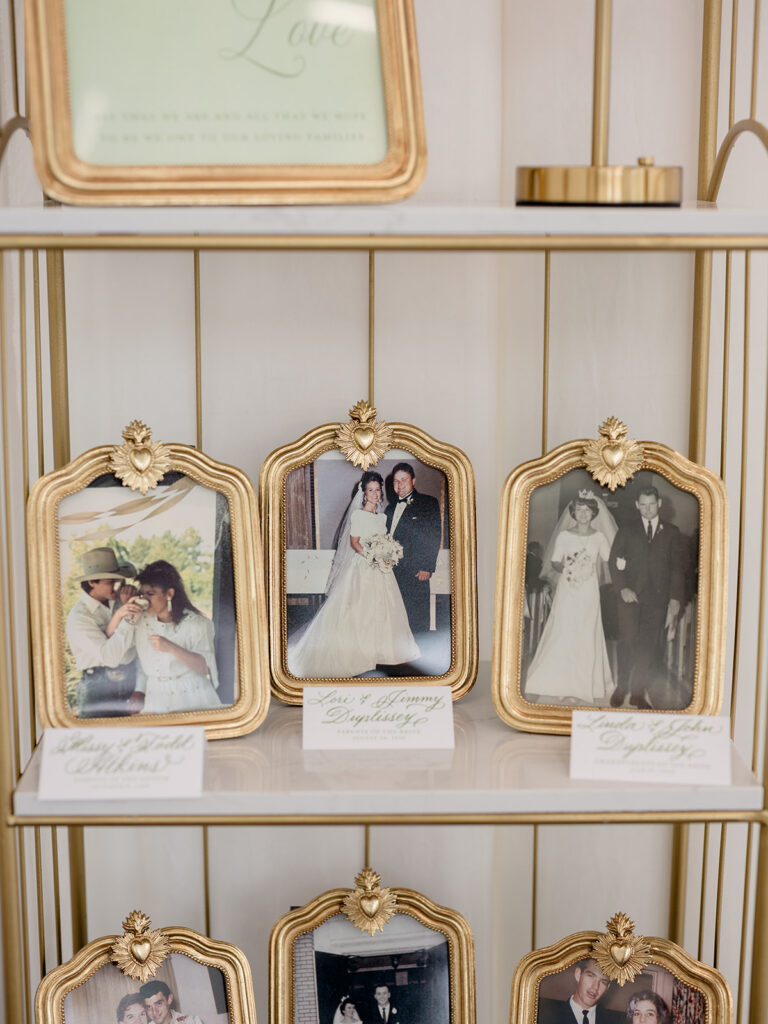 Gold framed family wedding photos displayed at the reception