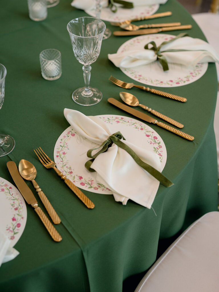 Green reception table setting with floral china and gold flatware