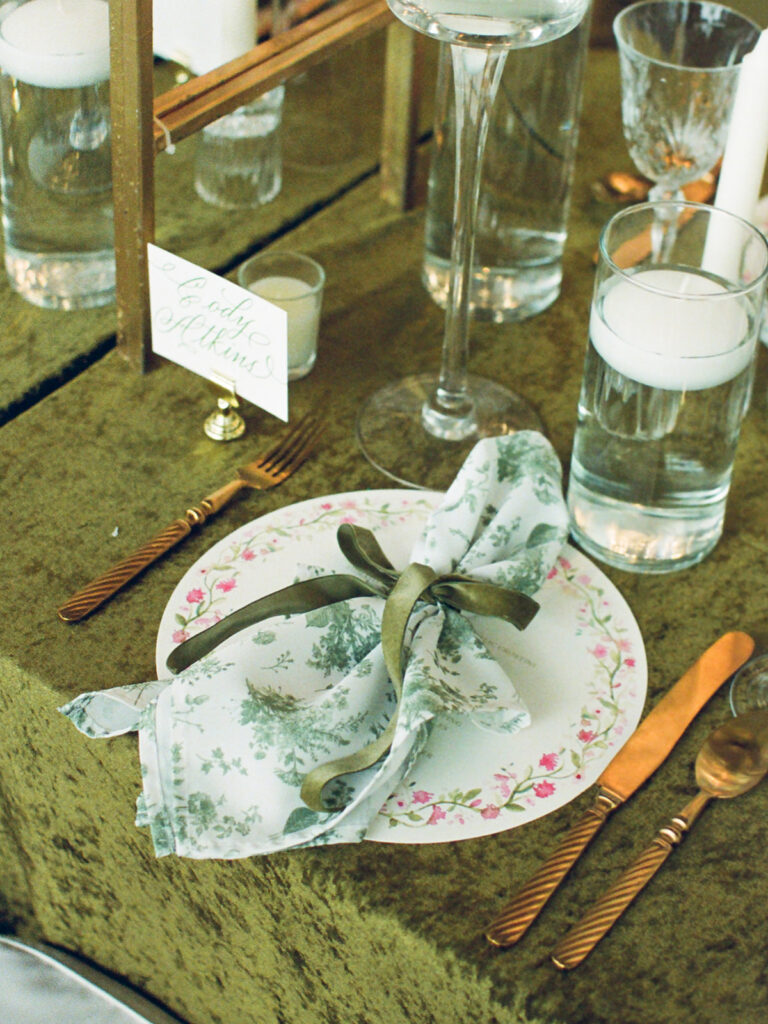 Green velvet table runner place setting with a toile napkin, photographed on film