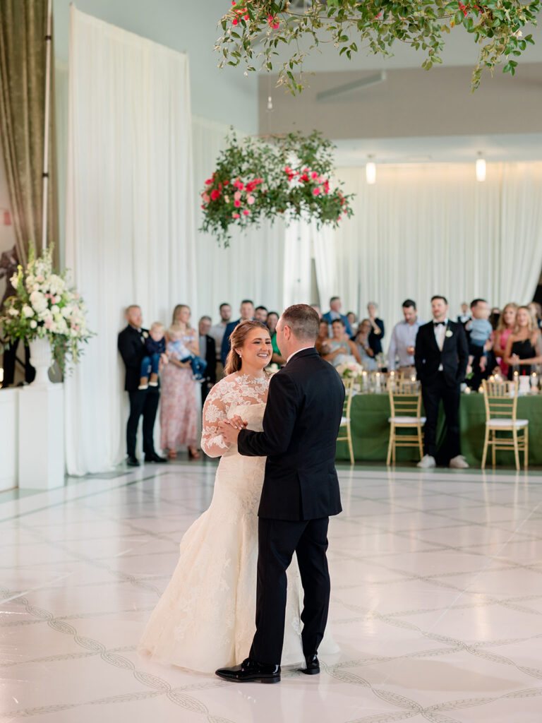 Bride and groom's first dance with guests gathered around