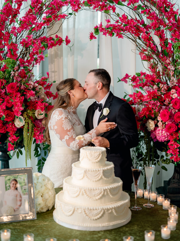 Bride and groom kissing after cutting the cake