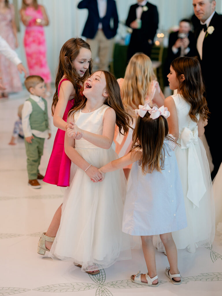 Little girls laughing and dancing together at the reception