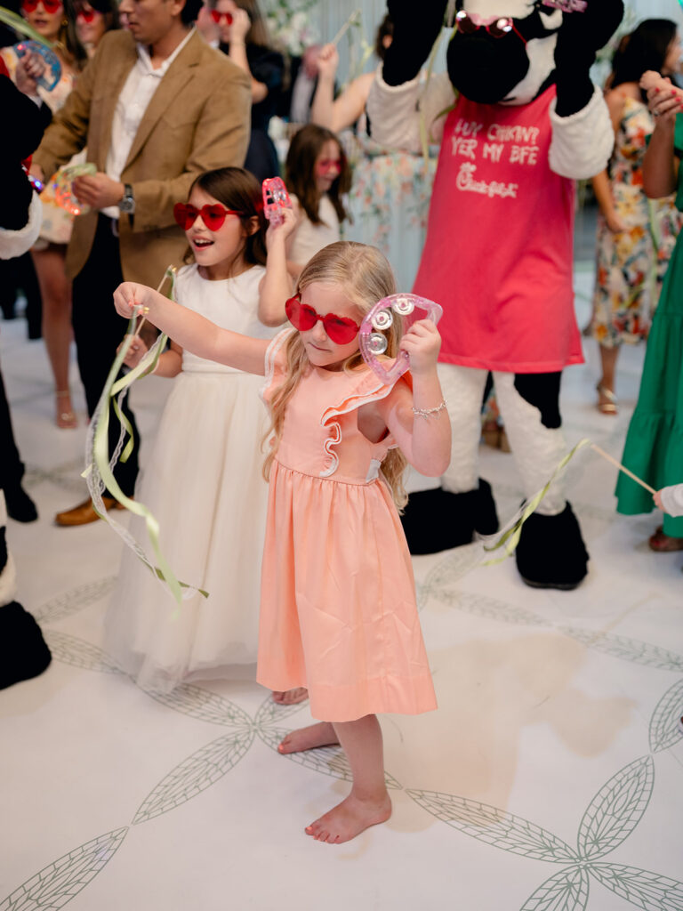 Kids in heart sunglasses dancing with ribbon wands