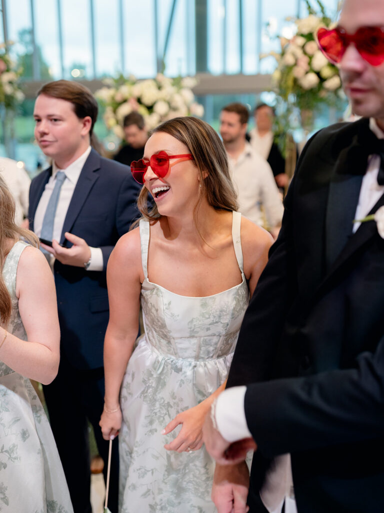 Guest laughing in heart sunglasses on the dance floor