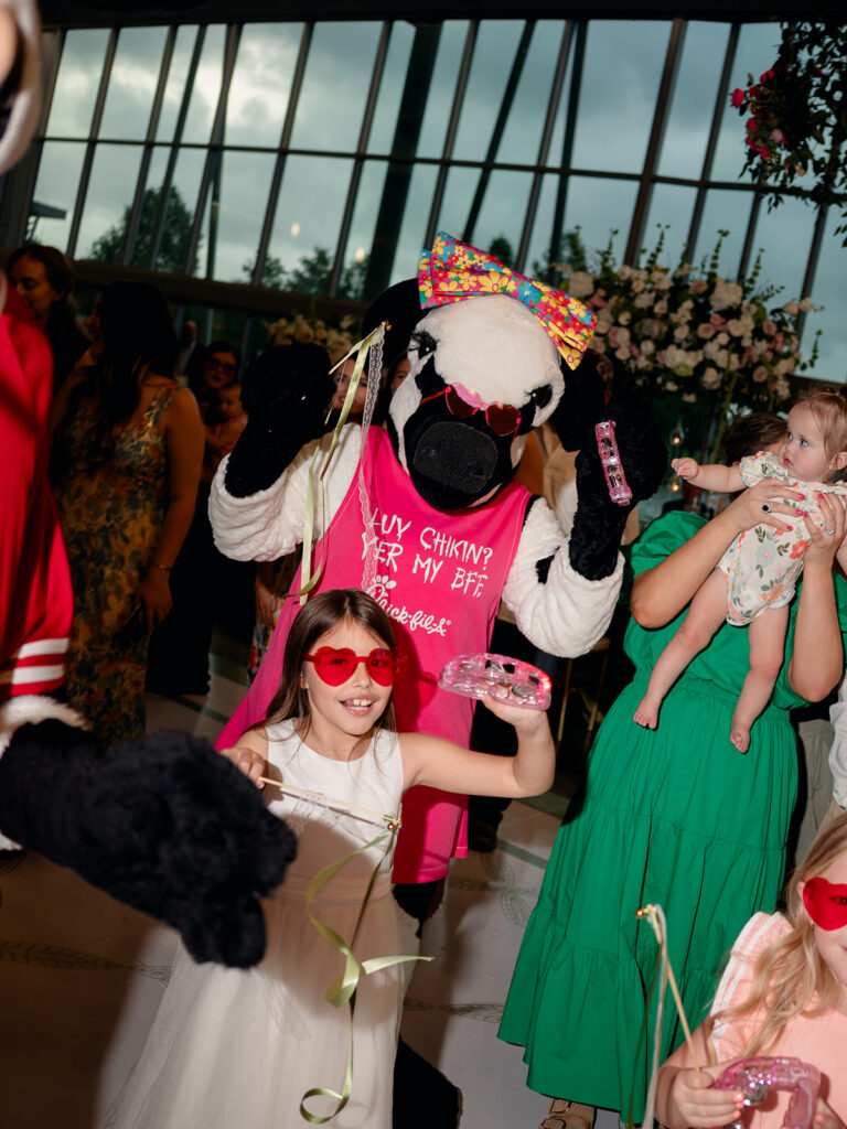 Kids dancing with the cow mascot at the reception