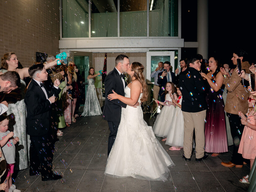 Bride and groom kissing during their grand exit